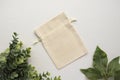 Blank drawstring canvas bag with green leaves mockup Royalty Free Stock Photo