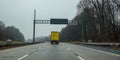 Blank electric digital road sign over a highway with a yellow truck directly underneath it. Royalty Free Stock Photo