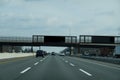 Blank electronic information sign over a busy multi-lane highway that says to move over and slow down for emergency vehicles.