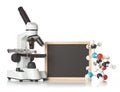 Blank, empty, black chalkboard with microscope, molecule model and DNA model over white