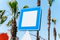 Blank empty copy space blue and white street sign with blue sky and palm trees in background. Mockup signpost Royalty Free Stock Photo