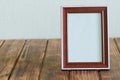 Blank empty photo frame for photos, pictures or announcements on a rustic vintage pine plank table. Textured pale green background Royalty Free Stock Photo
