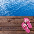 Blank empty tablet computer on beach. Trendy summer accessories on wooden background pool. Flip-flops on beach. Tropical flower or Royalty Free Stock Photo