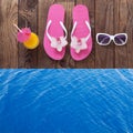 Blank empty tablet computer on beach. Trendy summer accessories on wooden background pool. Flip-flops on beach. Tropical flower or Royalty Free Stock Photo