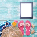 Blank empty tablet computer on beach. Trendy summer accessories on wooden background pool. Sunglasses, orange juice and Royalty Free Stock Photo