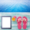 Blank empty tablet computer on beach. Trendy summer accessories on wooden background pool. Sunglasses, orange juice and Royalty Free Stock Photo