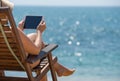 Blank empty tablet computer in the hands of women on the beach Royalty Free Stock Photo