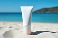 Blank empty white plastic tube Sunscreen lotion on sand