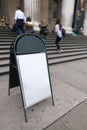 Blank empty white sign board on concrete floor in front of entrance way steps of building outdoor Royalty Free Stock Photo