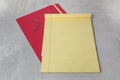 Blank empty yellow line legal pad notepad with red file folder background with paper clips with dead space