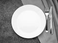 Blank flat white plate, fork on dark gray stone concrete table, top view. Mock up, copy space Royalty Free Stock Photo