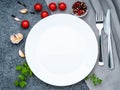 Blank flat white plate, fork on dark gray stone concrete table, top view. Mock up, copy space Royalty Free Stock Photo