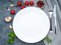 Blank flat white plate, fork on dark gray stone concrete table, top view. Mock up, copy space Royalty Free Stock Photo