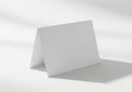 Blank folded card displayed on a white surface with subtle shadow patterns Royalty Free Stock Photo