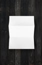 Blank folded White A4 paper sheet mockup template on black wood background Royalty Free Stock Photo