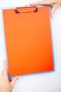 Blank Folder with ?range Paper. Hand that Holding Folder and Handle on White Background. Copyspace. Place for Text. Royalty Free Stock Photo