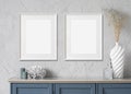 Blank frame mockup in modern interior design with blue sideboardand and flowers on empty gray wall background Royalty Free Stock Photo