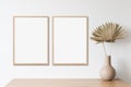 Blank frame mockup in modern interior design with vase and trendy plants on empty white wall background, Two vertical templates Royalty Free Stock Photo