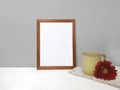 Blank frame mockup on table over stone wall Royalty Free Stock Photo