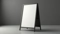 A blank A-frame sign mockup stands on a light gray surface against a dark gray studio background. This empty sandwich board is Royalty Free Stock Photo