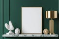 A blank frame sits elegantly against a deep emerald green wall, enhanced by a sleek marble console table. Modern Royalty Free Stock Photo