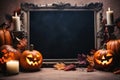 Blank frame for text with small pumpkins and candle in front of black wall. Halloween holiday, autumn concept Royalty Free Stock Photo