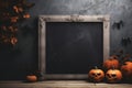 Blank frame for text with small pumpkins and spider in front of black wall. Halloween holiday, autumn concept Royalty Free Stock Photo
