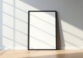 Blank framed artwork leaning against a wall with dramatic sunlight and shadow patterns Royalty Free Stock Photo
