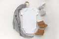Blank gender neutral white baby bodysuit close up - with toy and brown booties
