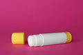 Blank glue stick and cap on fuchsia background