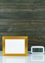 Blank golden frame and digital alarm clock on table Royalty Free Stock Photo