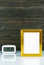 Blank golden frame and digital alarm clock on table Royalty Free Stock Photo