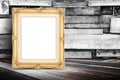 Blank golden vintage photo frame leaning at plank wood wall and Royalty Free Stock Photo