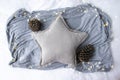 Blank gray star cushion surrounded by pine cones & heart lights- cosy winter Christmas scene