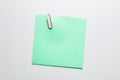 Blank green note paper or notepad with a red paper clip on white background with copy space Royalty Free Stock Photo