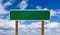 Blank Green Road Sign with Wooden Posts Over Blue Sky and Clouds Royalty Free Stock Photo