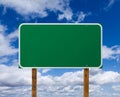 Blank Green Road Sign with Wooden Posts Over Blue Sky and Clouds Royalty Free Stock Photo