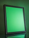 Blank green screen frame on green wall for creative mockups. Royalty Free Stock Photo