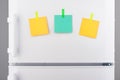 Blank green and yellow paper notes attached on refrigerator Royalty Free Stock Photo