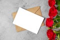 Blank greeting card and envelope with red rose flower on gray background. Wedding invitation. Mock up. Flat lay Royalty Free Stock Photo