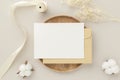 Blank greeting card invitation Mockup 5x7 on Brown envelope with dried flowers on beige background, flat lay, mockup Royalty Free Stock Photo