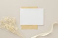 Blank greeting card invitation Mockup 5x7 on Brown envelope with dried flowers on beige background, flat lay, mockup Royalty Free Stock Photo