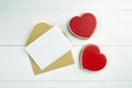 Blank greeting card mockup with paper envelope and red heart on white wooden table Royalty Free Stock Photo