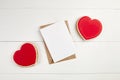 Blank greeting card mockup with paper envelope and red heart on white wooden table Royalty Free Stock Photo