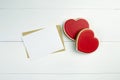 Blank greeting card mockup with paper envelope and red heart on white wooden table Royalty Free Stock Photo