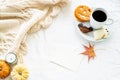 Blank greeting card mockup whit cup of coffee and cookies. Autumn, fall, halloween concept. Pumpkins and candle on white woolen Royalty Free Stock Photo