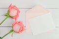 Blank greeting card with pink envelope and pink rose flowers