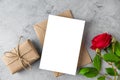 Blank greeting card with red rose flowers and gift box. Festive background. Mock up. Flat lay. Wedding invitation Royalty Free Stock Photo