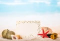 Blank greeting, star, Christmas toys, gifts in sand against sea. Royalty Free Stock Photo