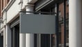 Blank grey rectangular sign hangs on modern shopfront in urban street. Empty banner ready for brand, ad, info, message, graphic. Royalty Free Stock Photo
